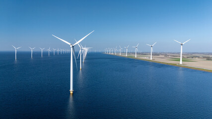 This expansive offshore windmill park features numerous wind turbines efficiently harnessing wind energy, Offshore windmill turbines in the ocean green energy transition in the Netherlands © Fokke Baarssen