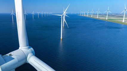 Spanning the tranquil waters, offshore windmill turbines stand tall against the clear skies of the...