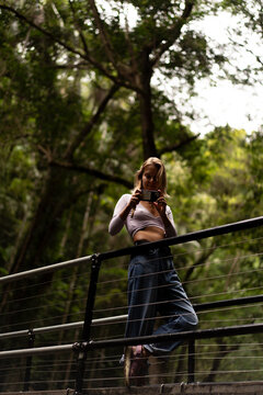 Woman takes a picture on the Waterfall trail in Australia