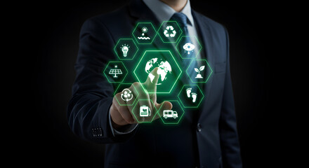 Businessman Touches Digital Earth Icon Surrounded by Environmental Concepts on Black Background