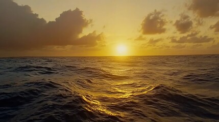 Ocean at sunset, with waves reflecting the golden light of the sun