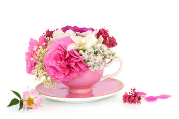 Pink tea cup floral abstract on white background. Summer flower surreal arrangement for natural alternative herbal medicine tea. Stress anxiety relieving adaptogen flora.