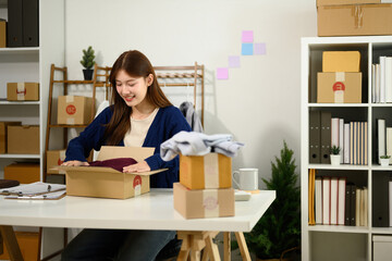 Young Asian Entrepreneur Woman Packing Product for E-commerce Delivery