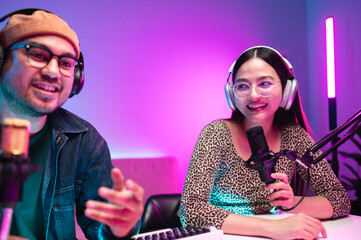 Teenagers, men and women, host podcasts in a room using LED lights, computers, headphones,...
