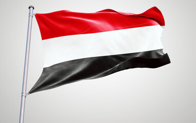 Flags of yemen waving in the wind on a pole with a clear sky background