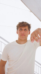 Young handsome man leaning on wall looking forward