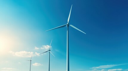 Fototapeta premium Three wind turbines stand against a clear blue sky, symbolizing renewable energy and sustainable technology.