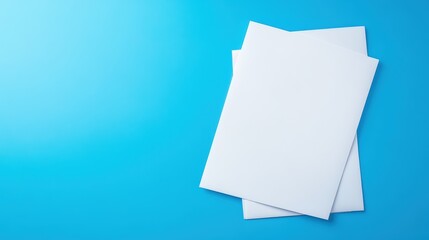 A clean, minimalistic arrangement of two blank white sheets of paper on a bright blue background.