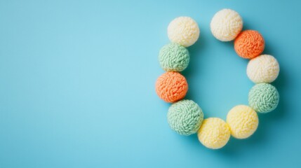 Obraz premium Artistic yarn balls placed in a crescent shape on a blue background, providing craft inspiration and design ideas