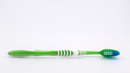 green toothbrush on white background close-up, side view