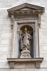 Statue of St. Gregorius with bird on main facade of St.Stephen`s Basilica is Roman Catholic basilica in Budapest, Hungary.  Vertical image