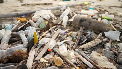 beach plastic pollution filled with bottles and other marine debris, ocean trash washed up on shore
