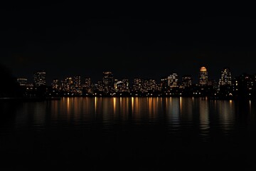 Obraz premium Boston Skyline at Night Across the Water with Boardwalk Pier
