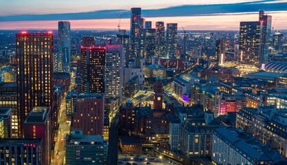 Aerial image of the illuminated Manchester Skyline at twilight. 