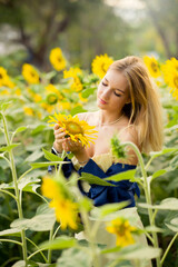 Cute european young model girl posing and having fun in a field full of blooming sun flowers. Showing freedom, innocence and youth
