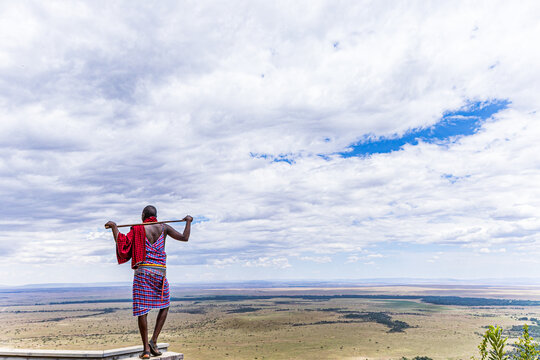 Maasai Man standing on the edge of the landscapes of the  Maasai Mara National Game Reserve Angama Mara Kenya People Cultural Traditional Heritage Festival Great Rift Valley Province Narok County Sava