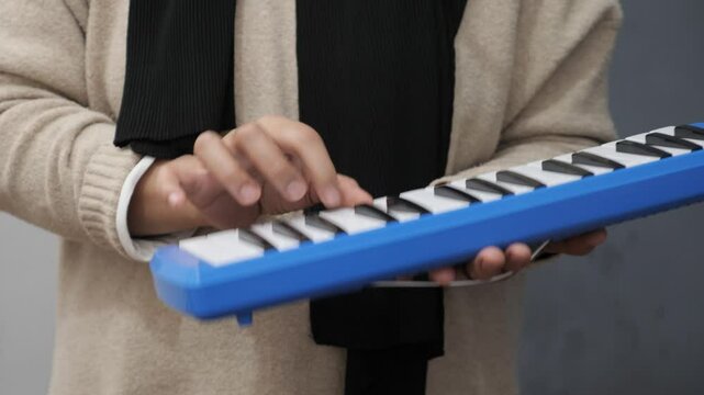 Anonymous woman playing pianica, melodica blow organ