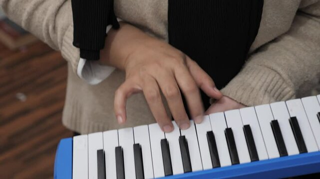 Anonymous woman playing pianica, melodica blow organ