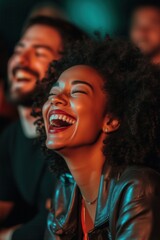 Group of people laughing at stand up comedy performance. Men and women with excited expressions on their faces.
