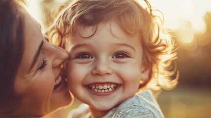 Happy young child smiling with mother kissing cheek