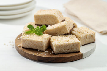 Delicious puffed rice bars and mint on white wooden table, closeup
