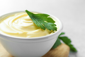 Delicious mayonnaise sauce with parsley in bowl on table, closeup