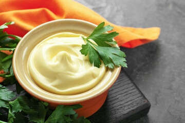 Delicious mayonnaise sauce in bowl with parsley on grey table, closeup