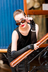 Young female model in black dress in Breakfast at Tiffany's style