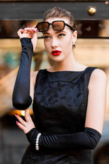 Young female model in black dress in Breakfast at Tiffany's style