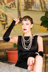 Young female model in black dress in Breakfast at Tiffany's style