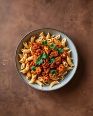 A spiced looking Cajun chicken pasta on a plain rustic brown background