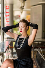 Young female model in black dress in Breakfast at Tiffany's style