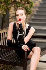 Young female model in black dress in Breakfast at Tiffany's style