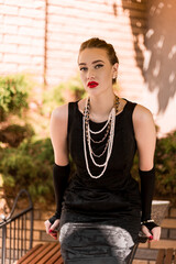 Young female model in black dress in Breakfast at Tiffany's style