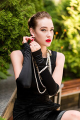 Young female model in black dress in Breakfast at Tiffany's style