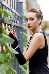 Young female model in black dress in Breakfast at Tiffany's style