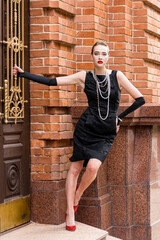 Young female model in black dress in Breakfast at Tiffany's style
