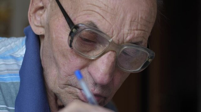 Close-up senior man using button calculator filling out tax form or payment documents, pensioner doing financial accounting