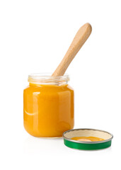 Baby food. Tasty puree in glass jar and spoon isolated on white
