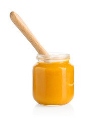 Baby food. Tasty puree in glass jar and spoon isolated on white