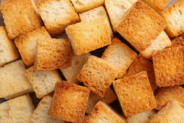 Tasty crispy croutons as background, top view