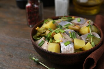 Delicious salad with herring on wooden table, closeup