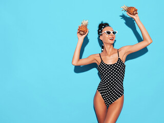 Portrait of smiling brunette model in summer peas swimwear bathing suit and sunglasses. Sexy woman...