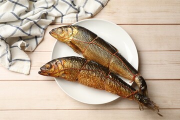 Delicious smoked herrings on white wooden table, top view