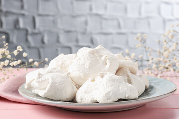Delicious homemade meringue cookies on pink wooden table, closeup