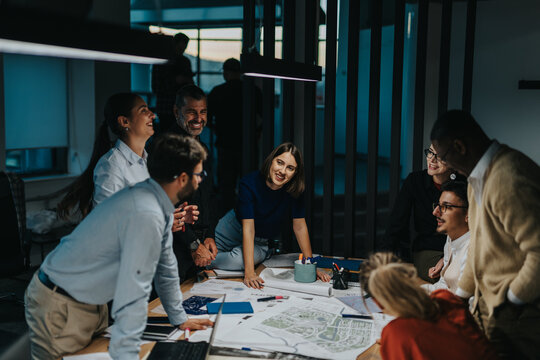 Diverse group of business people gather around a table, actively brainstorming and sharing ideas for a project. The atmosphere is vibrant and collaborative, emphasizing innovation and teamwork. - Powered by Adobe