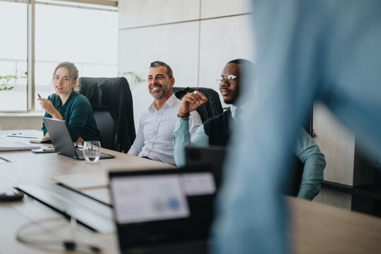 A diverse group of business people actively participate in a collaborative meeting. The atmosphere is focused and engaged, reflecting teamwork and open communication. Ideal for concepts of diversity