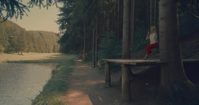 Woman Enjoying Nature on a Swing. Embraces lightness and freedom, surrounded by fresh air and greenery. Relaxation, happiness, connection to nature.