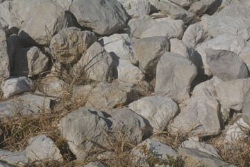 Natural stone textures showcasing various shades and shapes in a rocky landscape under sunlight