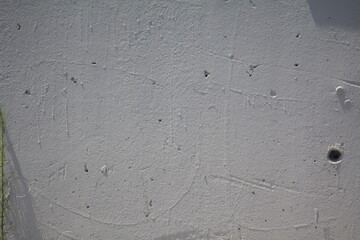 Unique texture of a weathered surface featuring various markings and natural imperfections in daylight